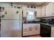 The kitchen has white cabinets, a sink under the window, and black appliances at 1095 Dallas Nebo Rd, Dallas, GA 30157