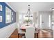 Elegant dining room featuring a wood table, white chairs, wainscoting, and a blue accent wall at 3514 Ethridge Nw Ln, Kennesaw, GA 30144