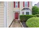 Close-up of the front door with a red door, a well-manicured front yard, and a bay window at 3514 Ethridge Nw Ln, Kennesaw, GA 30144