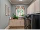 Well-lit laundry room featuring a utility sink, washer, dryer and neutral cabinets and decor at 118 Whitestone Dr, Mcdonough, GA 30253