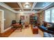 Comfortable home office with built-in bookshelves, coffered ceiling, and leather sofa at 118 Whitestone Dr, Mcdonough, GA 30253