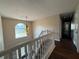 Well-lit hallway with wood floors, neutral walls, white trim and staircase, and a decorative light fixture at 257 Juliet Dr, Hampton, GA 30228