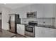 Bright kitchen featuring stainless steel appliances, grey cabinets and tile backsplash at 44 Peachtree Nw Pl # 2024, Atlanta, GA 30309