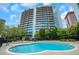 Stunning building featuring a pristine pool with ample lounge seating and well-maintained landscaping at 44 Peachtree Nw Pl # 2024, Atlanta, GA 30309