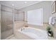 Bright bathroom with a jetted tub, separate tiled shower, and a shuttered window at 66 Mobile Ne Ave, Atlanta, GA 30305