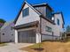 Side view of a painted-brick modern home with black trim and a two car front-entry garage at 1240 Hayes Sq, Peachtree City, GA 30269