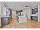 An open-concept kitchen features a large island, stainless appliances, and modern lighting fixtures at 1240 Hayes Sq, Peachtree City, GA 30269