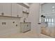 Laundry area featuring white cabinets and sink, with a view into an open plan living area at 1240 Hayes Sq, Peachtree City, GA 30269