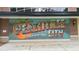 Colorful mural that reads Greetings from Peachtree City Georgia on a brick building facade at 1240 Hayes Sq, Peachtree City, GA 30269