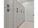Hallway featuring rows of sleek white storage cabinets and black hardware at 1240 Hayes Sq, Peachtree City, GA 30269