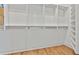 Spacious walk-in closet featuring custom white shelving, rods, and hardwood flooring at 1240 Hayes Sq, Peachtree City, GA 30269