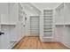 Spacious walk-in closet with custom white shelving and storage, and hardwood floors at 1240 Hayes Sq, Peachtree City, GA 30269
