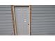 An exterior view of a gray entry door with wood trim on a building with gray siding at 1285 North Nw Ave, Atlanta, GA 30318