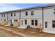 Backyard view of townhomes with patios, brick foundations and fenced-in yards at 504 Amethyst Way, Stockbridge, GA 30281