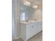 Bathroom with a double sink vanity, large mirror, and wood-look tile flooring at 504 Amethyst Way, Stockbridge, GA 30281