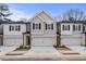 New townhomes in a row feature neutral colors, garage and inviting curb appeal on a sunny day at 504 Amethyst Way, Stockbridge, GA 30281