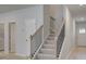 Carpeted stairway with wood and iron railing leads to the upper level and overlooks the entryway at 504 Amethyst Way, Stockbridge, GA 30281