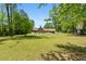 Beautiful backyard with lush green lawn, mature trees, and a glimpse of the inviting pool and outdoor living space at 3222 Bay View Dr, Jonesboro, GA 30236