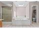 Well-lit bathroom with a soaking tub, shower, and skylight at 3222 Bay View Dr, Jonesboro, GA 30236