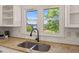 Close-up of a kitchen sink with granite countertops and a view of the backyard at 3222 Bay View Dr, Jonesboro, GA 30236