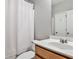 Cozy bathroom with a white shower curtain, wooden cabinet, and a sink at 334 Pin Oak Ave, Woodstock, GA 30188