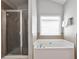 Bathroom with a shower, garden tub, window, and tile floor at 334 Pin Oak Ave, Woodstock, GA 30188