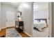 Inviting entryway with a white door, a stylish table with a lamp, and a peek into the bedroom at 334 Pin Oak Ave, Woodstock, GA 30188