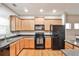 Well-lit kitchen boasts granite countertops, hardwood floors, wood cabinets, and stainless steel appliances at 334 Pin Oak Ave, Woodstock, GA 30188