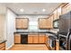 Galley kitchen featuring wooden cabinets, granite countertops, hardwood floors, and stainless steel appliances at 334 Pin Oak Ave, Woodstock, GA 30188