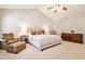Bedroom features a ceiling fan, chair, dresser, bedside table and carpet at 334 Pin Oak Ave, Woodstock, GA 30188