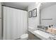 Bathroom features a white shower curtain, modern gray vanity, sink, and framed art at 3512 Lynview W Ct, Decatur, GA 30034
