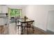 Open-concept dining area featuring hardwood floors and a glass-top table with a backyard view at 3512 Lynview W Ct, Decatur, GA 30034