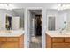En suite bathroom with dual sinks, wood cabinetry, and entry to walk in closet at 4092 Grand Park Dr, Suwanee, GA 30024