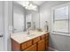 Bathroom vanity featuring wood cabinets, solid surface countertops, and a large mirror at 4092 Grand Park Dr, Suwanee, GA 30024