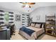 bedroom with gray walls, a bed, desk, bookshelves, and large windows at 4092 Grand Park Dr, Suwanee, GA 30024