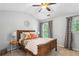 Cozy bedroom featuring a wood-frame bed, neutral walls, a ceiling fan, and bright windows at 4092 Grand Park Dr, Suwanee, GA 30024