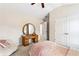 A comfy bedroom with a vanity area, a bed with pink bedding, and a round fluffy chair at 4092 Grand Park Dr, Suwanee, GA 30024
