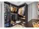 Walk in closet featuring dark shelving, hanging clothes, a stool, and lots of shoes at 4092 Grand Park Dr, Suwanee, GA 30024