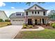 Charming two-story home with a well-manicured lawn, attached two-car garage, and a welcoming front porch with columns at 4092 Grand Park Dr, Suwanee, GA 30024