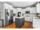 Modern kitchen with stainless steel appliances, white cabinets, and a gray island at 4092 Grand Park Dr, Suwanee, GA 30024
