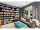 Cozy living room featuring custom built-in bookshelves, a comfortable sofa, and a large window with natural light at 4092 Grand Park Dr, Suwanee, GA 30024