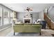 Open living room showcasing a fireplace, green sofa, neutral walls, and staircase at 4092 Grand Park Dr, Suwanee, GA 30024