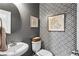 Stylish powder room with modern fixtures, patterned wallpaper, and decorative framed prints at 4092 Grand Park Dr, Suwanee, GA 30024