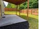 A backyard featuring a concrete patio, wooden fence, and lush lawn at 4605 Fourth Rail Ln, Cumming, GA 30040
