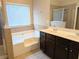 A bathroom featuring a soaking tub with tile surround, walk-in shower, and double vanity at 4605 Fourth Rail Ln, Cumming, GA 30040