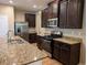 Well-equipped kitchen with granite countertops, stainless steel appliances, and dark wood cabinetry at 4605 Fourth Rail Ln, Cumming, GA 30040