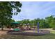 A colorful playground with slides and swings is surrounded by lush green trees at 4605 Fourth Rail Ln, Cumming, GA 30040
