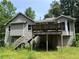 Rear exterior view of the house with an elevated wooden deck and stairs leading to the backyard at 554 Oak Landing Cir, Douglasville, GA 30134