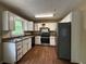 Functional kitchen with white cabinetry, black appliances, and wood-look flooring at 554 Oak Landing Cir, Douglasville, GA 30134
