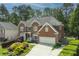 Classic brick home featuring a well-kept lawn, mature trees, and an attached two-car garage at 6317 Benbrooke Overlook Nw, Acworth, GA 30101
